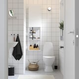 ENHET bathroom storage: white, tiled, sleek with mirror and towel, compact toilet, basket & bin.