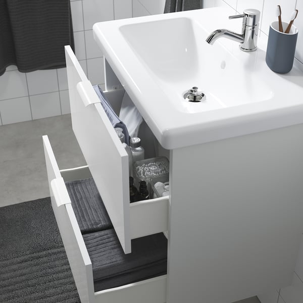 Bathroom sink unit with storage drawers, mixer tap, and water trap in glossy white.
