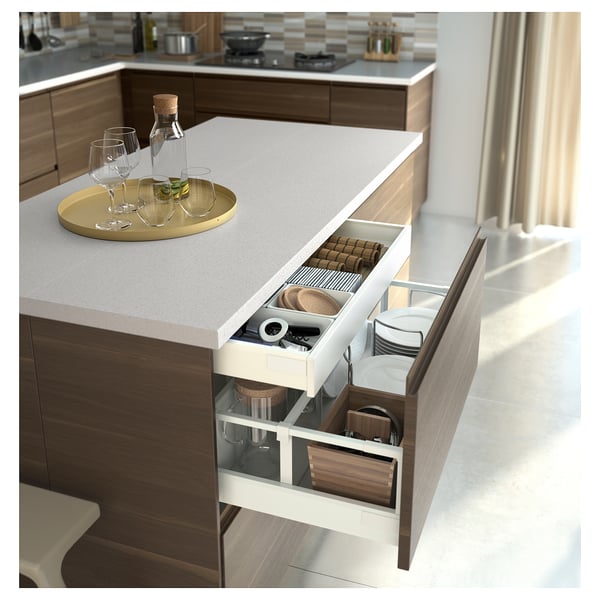Modern kitchen with wide push-to-open drawers in brown, containing organized utensils and items, setup neatly for easy access.