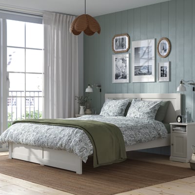 Off-white FÅGELFJÄLLET bed, grey walls, patterned bedding, wicker pendant, large window, artworks, bedside tables