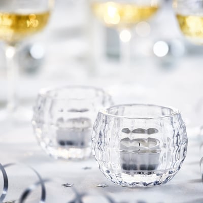 FRÖJDA clear glass tealight holder, round, faceted design.