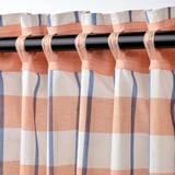 Peach, white, and blue striped curtains hang neatly, filtering light. Backside shows heading tape for versatile mounting.