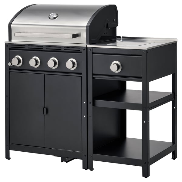 Black outdoor kitchen with stainless steel gas grill and side burner, four burners, and storage.