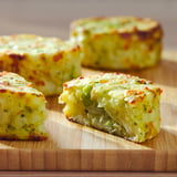 Four cheese and veggie casseroles on wooden board, golden-brown top, rectangular shape.
