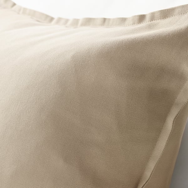 Close-up of beige cotton cushion cover, showcasing smooth texture and neat stitching for quality detail.