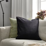 GURLI: black cotton throw pillow on beige couch, rectangular, plush, medium size.