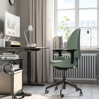 Ergonomic HATTEFJÄLL office chair at a modern desk with computer, natural light, and radiator.