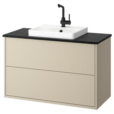 Beige wooden bathroom vanity with black countertop and square white basin.