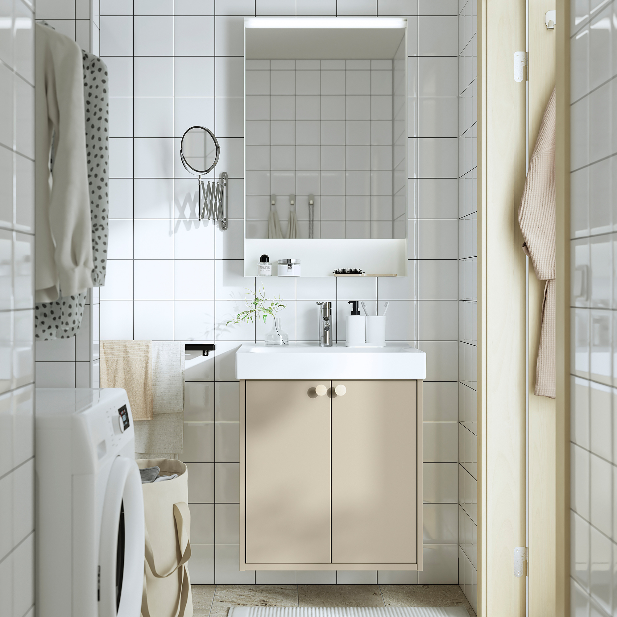 Minimalist bathroom with beige HAVBÄCK vanity, white sink, large mirror, and closed storage. Washing machine beside, light neutral colors.