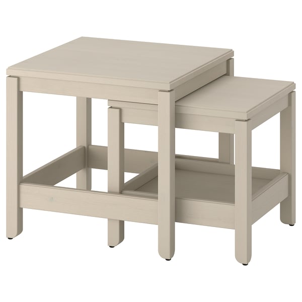 Two light beige wooden tables, one larger and one smaller, nested together with clean, simple lines, perfect for space-saving.
