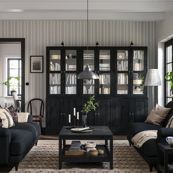 Living room with black HAVSTA bookcases, dark blue sofa, patterned rug, and striped wallpaper.