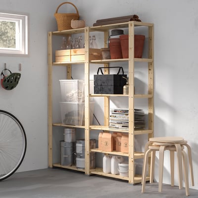 HEJNE wooden storage shelves in garage, holding various items, with a white stool beside it.