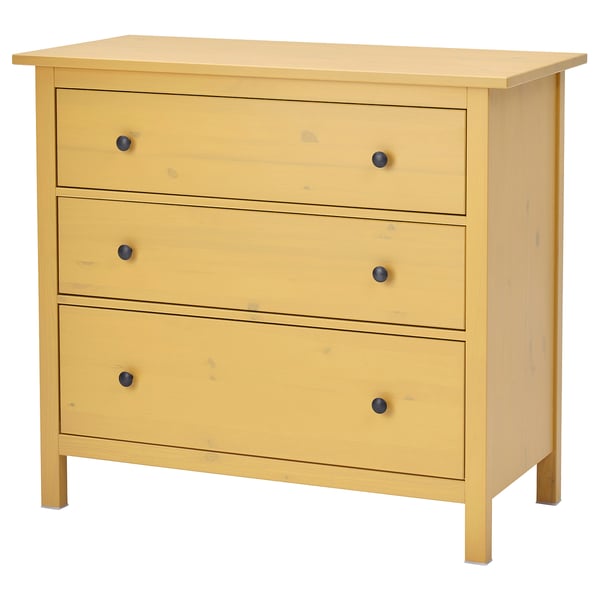 A HEMNES wooden chest of drawers in yellow, featuring three drawers with black knobs. Its rectangular with a simple, classic design.