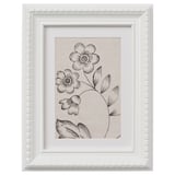 This describes a white framed picture with a black-and-white floral design.