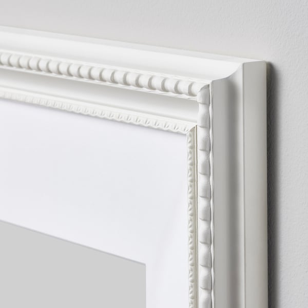 Elegant white beaded picture frame, mounted on wall with intricate details, showcasing high-quality craftsmanship.