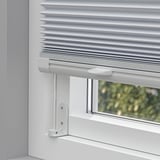 White pleated blind mounted on a window with light control, cordless handles for safety, versatile mounting options.