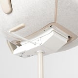 Under desk, white adjustable stand-up table with sturdy design and support. Modern office furniture setup.