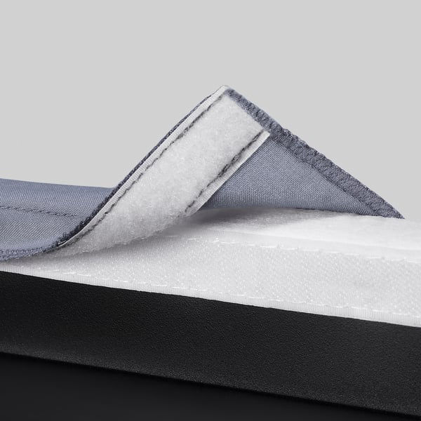 Close-up of layered chair material: soft, sturdy fabric, thick cushion, supportive foam.