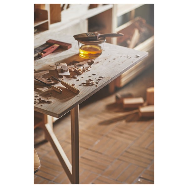Woodworking station with tools and oil on a table.