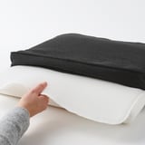 Person lifting chair cushion showing non-slip underside.