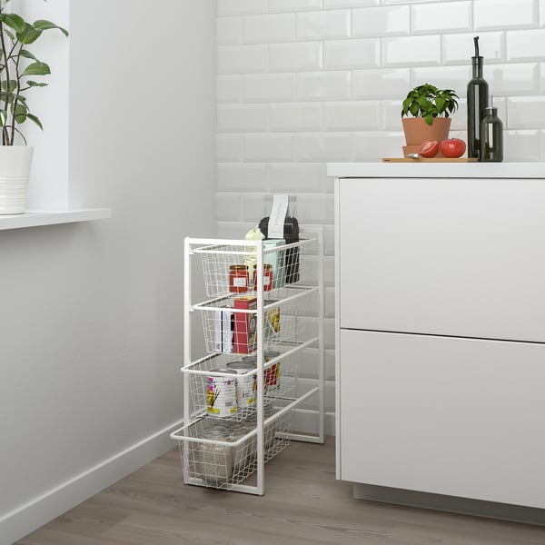 White JONAXEL rack with wire baskets in kitchen corner, neatly organizing small space.