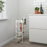 White JONAXEL rack with wire baskets in kitchen corner, neatly organizing small space.