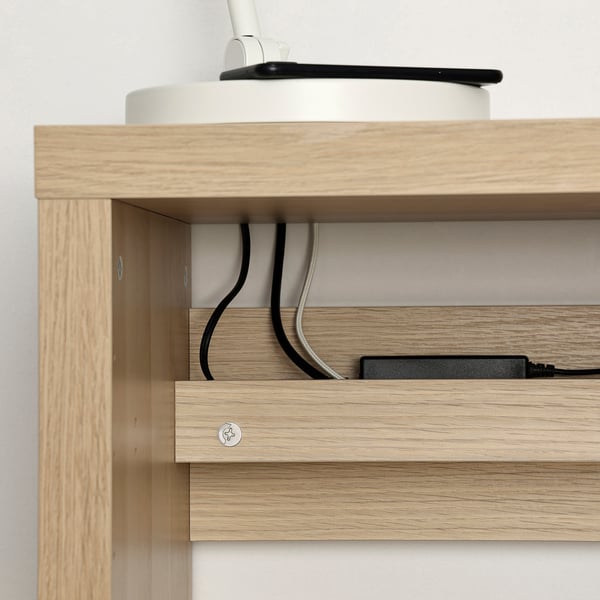 Wooden desk with cables routed through back, promoting tidy and efficient workspace.
