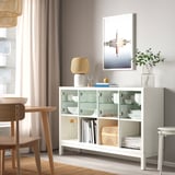 White KALLAX shelving unit, modern, featuring glass doors, and wooden accents, prominently displayed in a cozy living space.
