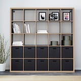 KALLAX shelving unit with boxes, books, photos, and plant.