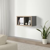 Modern living room with KALLAX shelf, books, clock, frame, cream chair, plant.