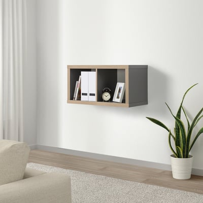 Modern living room with KALLAX shelf, books, clock, frame, cream chair, plant.