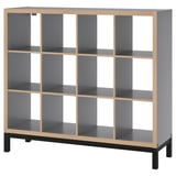 A KALLAX shelf unit in gray with light wood accents and black legs. It has a modular, cube-like design with open compartments.