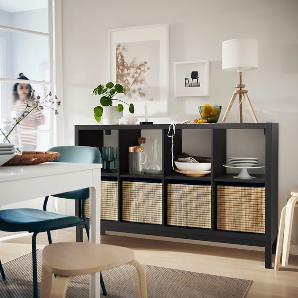 Modern living room KALLAX black shelving unit with woven inserts, decorative items, and stylish seating.