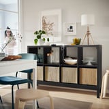 Modern living room KALLAX black shelving unit with woven inserts, decorative items, and stylish seating.