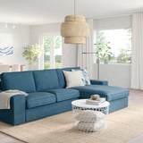 Living room with blue KIVIK sofa, white table, pendant lamp, and large windows.