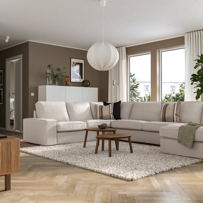 Living room with large KIVIK sofa, light grey, large window, wooden floor, and decorations.