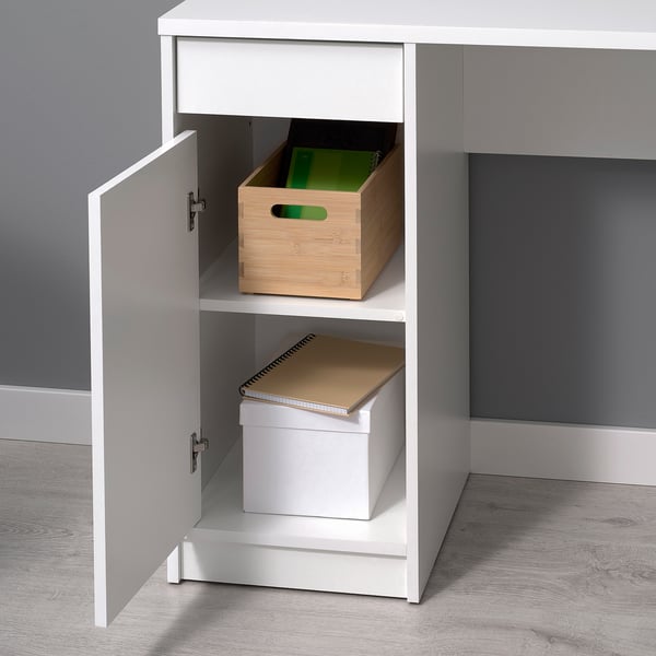 White desk with adjustable shelves and a drawer, storing wooden and cardboard boxes.