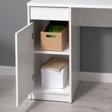 White desk with adjustable shelves and a drawer, storing wooden and cardboard boxes.