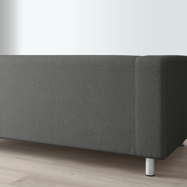 A dark grey KLIPPAN sofa with metal legs on a wooden floor.
