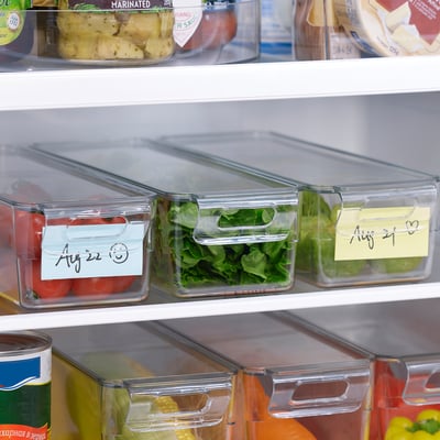 Fridge organizer boxes with lids store veggies, labeled for dates, stackable.