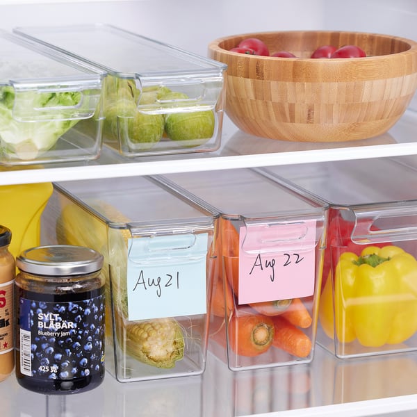 Fridge with organized veggies in stackable containers with date labels.