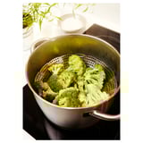 Stainless steel steamer with broccoli on stovetop.