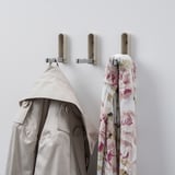 Three hooks hold coat, scarf, and are empty. Or, hooks hold coat, scarf, one empty.