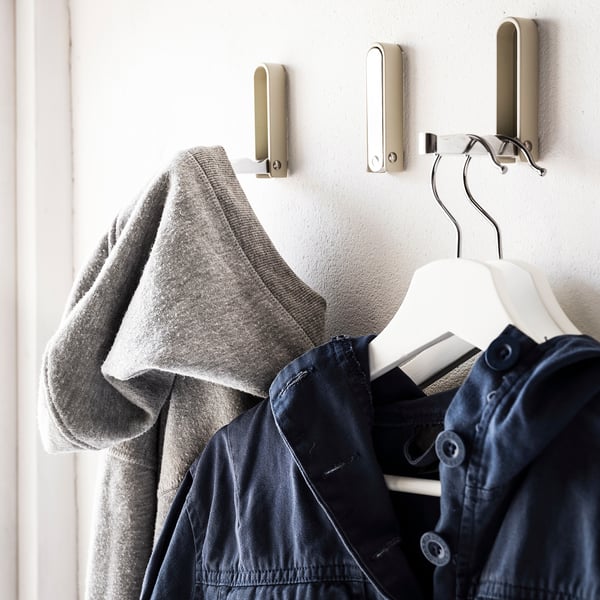 KLYKET hooks, silver metallic, triangular shape, holding gray sweater and navy jacket.