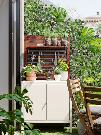 Styler outdoor mini cabinet, white, metal, rectangular, simple design, green plants around.