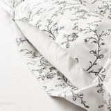 White duvet with floral pattern featuring snap closures, ensuring it stays securely in place.