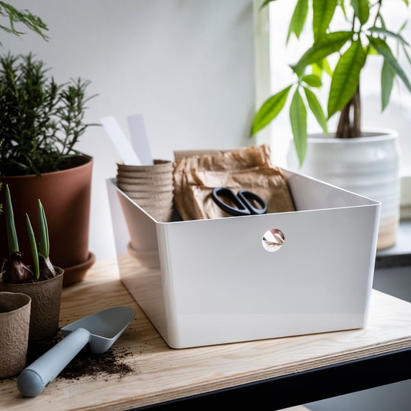 White KUGGIS recycle plastic box, rectangular, holds gardening tools on table.
