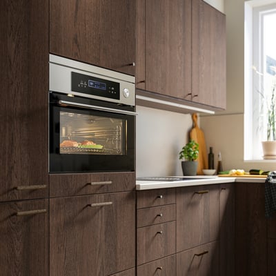 Modern oven with digital display, stainless steel handle, and glass door showcasing racks inside.