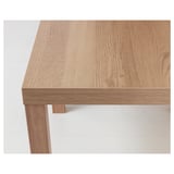 Close-up view of rectangular wooden table. Highlights smooth, light-colored finish and sturdy construction.