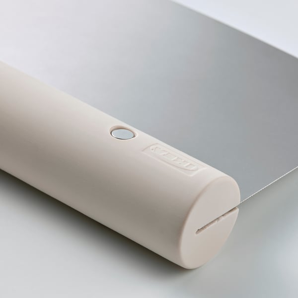 Cylindrical white plastic tool with embedded stainless steel blade, branded LÄTTBAKAD.